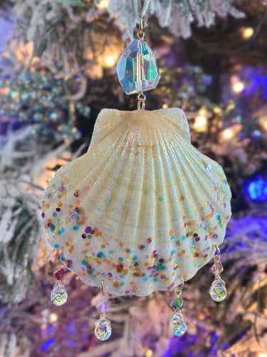 Decorative shell ornament with colorful beads and crystal accents on a Christmas tree.