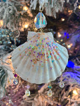 Decorative shell ornament with beads and crystals on a Christmas tree.