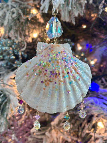 Decorative shell ornament with beads and crystals on a Christmas tree.