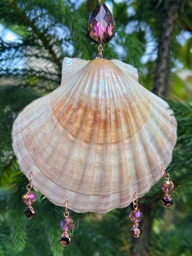 Shell ornament with decorative beads against a blurred green background